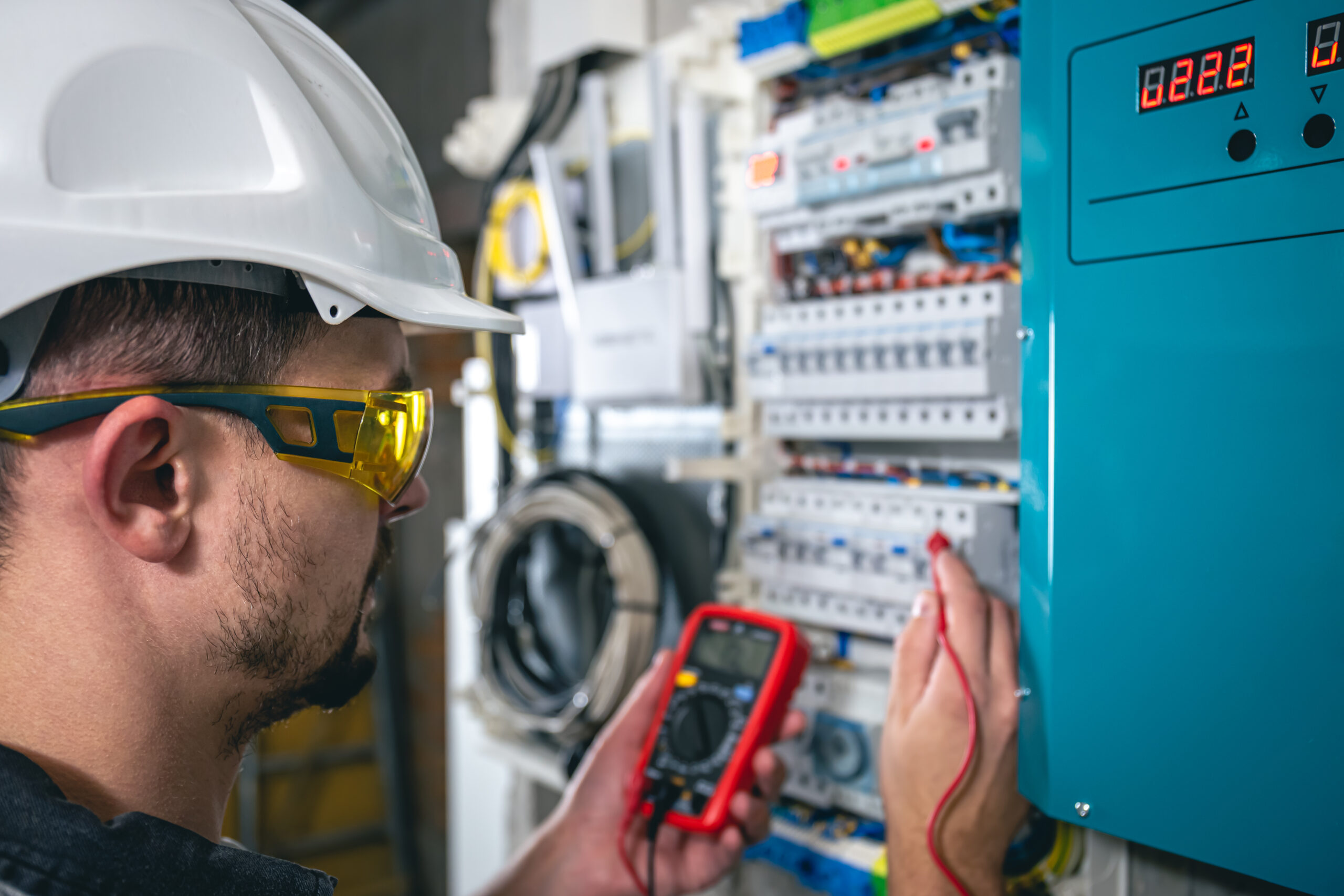 Man, an electrical technician working in a switchboard with fuses.